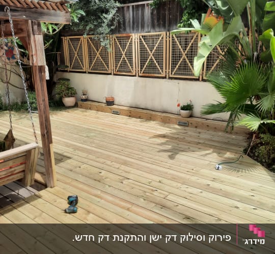 דק עץ עם כלי עבודה וצמחייה מסביב